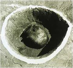 柱穴の中の瓦質四耳壷（がしつしじこ）の写真